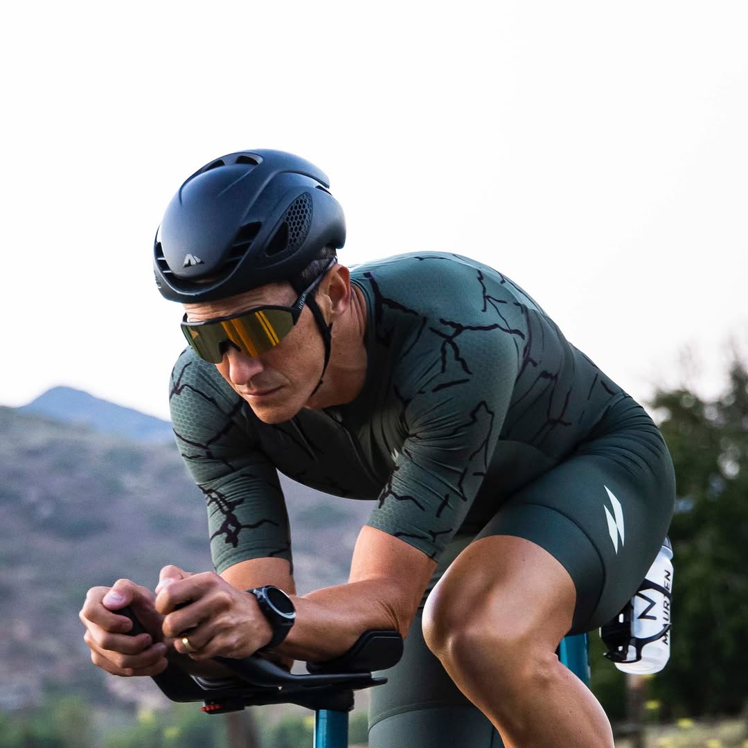 Cyclist in mountainous terrain wearing a helmet and sunglasses.