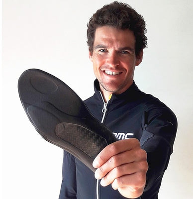 Greg Van Avermaet holding a solestar insole against a white background