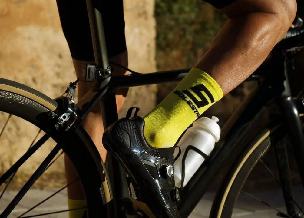 Pro cyclist using solestar socks yellow one and riding a bike